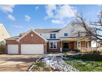 Two-story brick home with attached garage and landscaping at 1027 Southbury Pl, Highlands Ranch, CO 80129