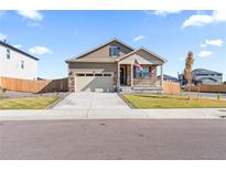 Beige ranch home with a two-car garage at 13408 Wabash St, Thornton, CO 80602