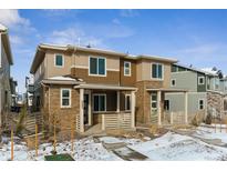 Tan and brown two-story townhome with a modern design and small front yard at 8683 Snake River St, Littleton, CO 80125