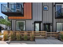 Modern townhouse entrance with a wooden fence and balcony at 5570 W 11Th Pl, Lakewood, CO 80214