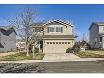 Two-story house with beige siding, attached garage, and landscaped lawn at 9605 Elk Mountain Cir, Littleton, CO 80125