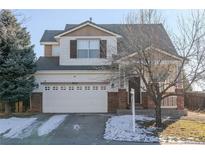 Two-story brick home with attached garage and snowy landscaping at 9551 Longford Way, Parker, CO 80134