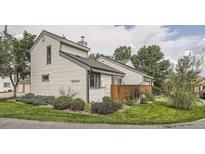 Exterior view of light beige siding townhouse with green lawn at 8520 S Estes St # H, Littleton, CO 80128