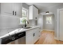 Renovated kitchen with white shaker cabinets, quartz countertops, and stainless steel appliances at 2103 S Lafayette St, Denver, CO 80210