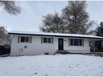 Newly painted Ranch home with snow-covered yard at 6513 Teller St, Arvada, CO 80003