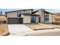 Modern two-story home with attached garage and stone accents at 7469 Skygazer St, Castle Pines, CO 80108