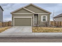 One-story house with a green exterior, attached garage, and a small front yard at 7203 Arkansas St, Frederick, CO 80530