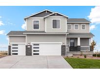 Two-story house with gray siding, white garage doors and stone accents at 42972 Colonial Trl, Elizabeth, CO 80107