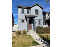 Two-story house with gray siding, red door, and landscaped front yard at 19085 E 66Th Ave, Denver, CO 80249