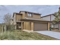 Two-story house with attached garage and landscaped front yard at 11753 Pennsylvania St, Northglenn, CO 80233