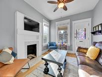 Living room features a fireplace, hardwood floors and a ceiling fan at 4112 Raritan St, Denver, CO 80211