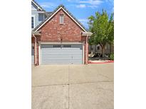 Attached garage with gray door, belonging to a brick home at 22975 E Ontario Dr # 101, Aurora, CO 80016