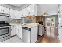 Kitchen with white cabinets, stone accent wall, and stainless steel appliances at 8140 S Fillmore Cir, Centennial, CO 80122