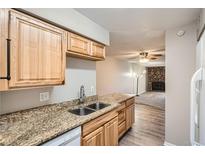 Kitchen features granite countertops, light wood cabinets, and stainless steel sink at 865 S Quebec St # 104B, Denver, CO 80247