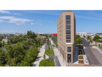 Modern multi-story building with river views and nearby green space at 3575 Chestnut Pl # 606, Denver, CO 80216