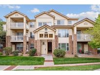 Beige three-story condo building with balconies and landscaping at 5703 N Gibralter Way # 204, Aurora, CO 80019
