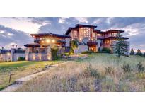 Luxury home exterior with stone accents and expansive windows at dusk at 24503 Chris Dr, Evergreen, CO 80439