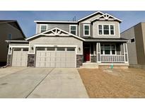 Two-story home with gray siding, a red door, and a two-car garage at 25061 E 38Th Ave, Aurora, CO 80019