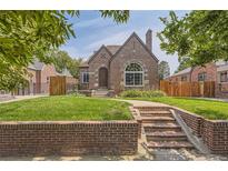 Charming brick home with a landscaped lawn and walkway at 1460 Tennyson St, Denver, CO 80204