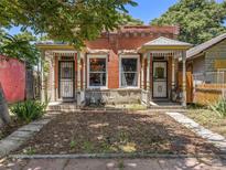 Brick duplex with charming porches and well-maintained landscaping at 319 Delaware St, Denver, CO 80223