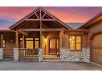 Rustic two-story home with a covered front porch at 26165 Amy Cir, Conifer, CO 80433