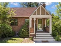 Brick house with a covered front porch and landscaped yard at 1441 Dahlia St, Denver, CO 80220