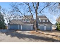 Gray townhouse exterior with a three-car garage and landscaping at 8099 S Trinchera Peak, Littleton, CO 80127