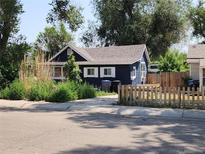 Charming bungalow with a dark blue exterior, white trim, and a small front yard at 230 Emery St, Longmont, CO 80501