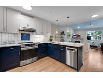 Modern kitchen with blue cabinets, stainless steel appliances, and an island at 3091 29Th St # 103, Boulder, CO 80301