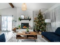 Cozy living room features a fireplace, a Christmas tree, and ample natural light at 29116 Pine Rd, Evergreen, CO 80439