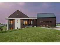 Modern farmhouse exterior boasts a metal roof and dark wood siding at 11229 Running Kit Pl, Franktown, CO 80116