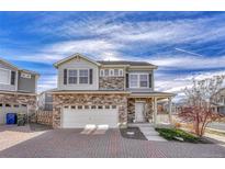 Two-story townhome with stone and shingle exterior, two-car garage, and paved driveway at 224 S Old Hammer St, Aurora, CO 80018