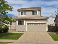 Two-story house with a two car garage and front yard at 19877 E 40Th Ave, Denver, CO 80249