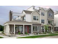 Two-story modern home with brick exterior, covered porch, and rooftop deck at 888 S Valentia St # 106, Denver, CO 80247