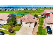 Aerial view of a ranch style home with a three-car garage and golf course views at 5183 Kirk Ct, Denver, CO 80249