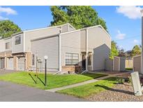 Tan siding townhouse with a small front yard and walkway at 8787 Yukon St, Arvada, CO 80005