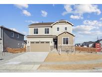 Two-story house with beige siding, wood accents, and a landscaped yard at 1381 Rock Cliff Ave, Erie, CO 80516