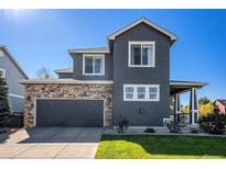 Two-story house with gray siding, stone accents, and a two-car garage at 5558 Longs Peak St, Brighton, CO 80601