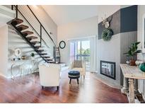 Bright living room with hardwood floors, fireplace, and modern furnishings at 10785 W 63Rd Pl # 307, Arvada, CO 80004