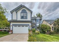 Two-story house with a white and blue exterior, two-car garage, and well-maintained lawn at 17045 Hastings Ave, Parker, CO 80134