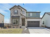 Two-story home with stone and siding exterior, two-car garage, and landscaped yard at 5960 S Platte Canyon Dr, Littleton, CO 80123