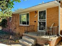 Brick ranch home with a covered porch and landscaping at 2542 S Winona Ct, Denver, CO 80219