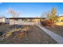 Ranch style home with a landscaped yard at 832 S Quivas St, Denver, CO 80223