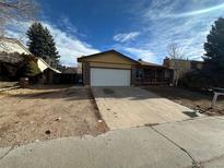 Ranch style home with a two-car garage and mature landscaping at 2084 S Rifle St, Aurora, CO 80013