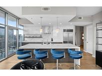 Modern kitchen with marble countertops and blue barstools at 1700 Bassett St # 1901, Denver, CO 80202