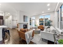 Spacious living room with hardwood floors and fireplace at 9385 E Prairie Meadow Dr, Denver, CO 80238