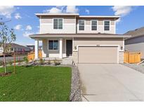 Two story house with light beige siding and a two-car garage at 4623 Ambrose Pl, Brighton, CO 80601