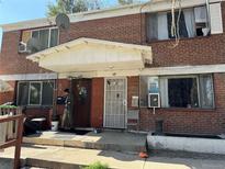 Brick duplex with a front porch and landscaping at 1125 S Raritan St, Denver, CO 80223