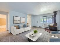 Bright living room features a fireplace and is furnished with a sofa and coffee table at 2565 S Sheridan Blvd # 20, Denver, CO 80227