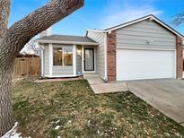 Ranch style home with attached garage and mature tree in front yard at 4635 Sable St, Denver, CO 80239